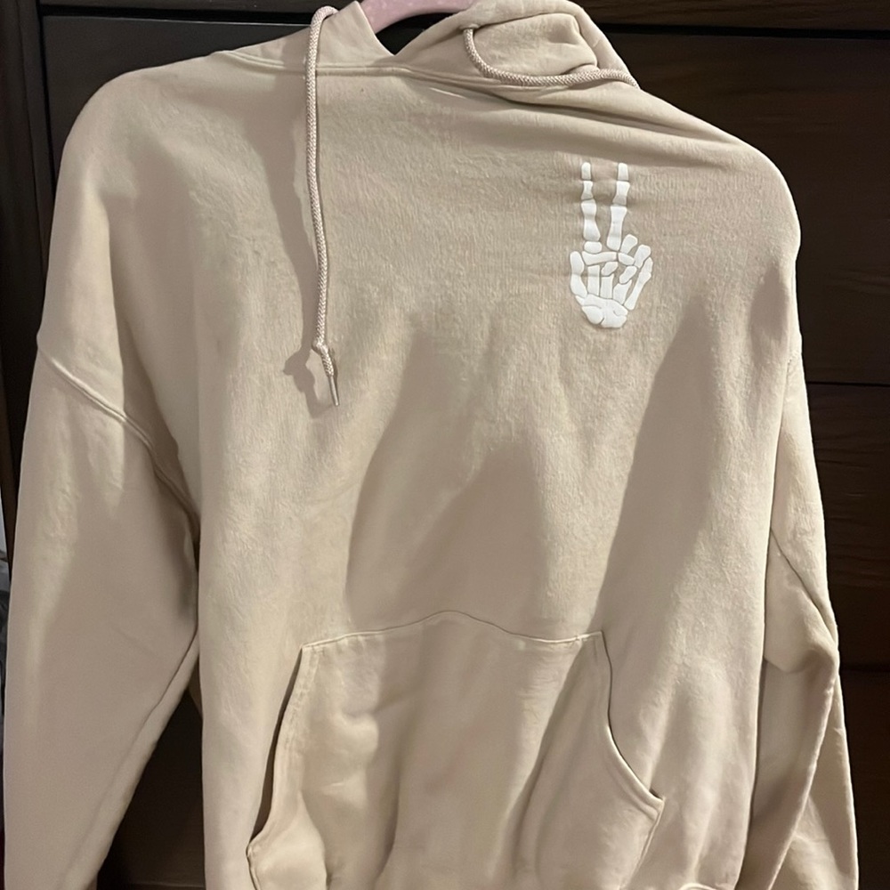 Beige hoodie with skeleton peace sign
